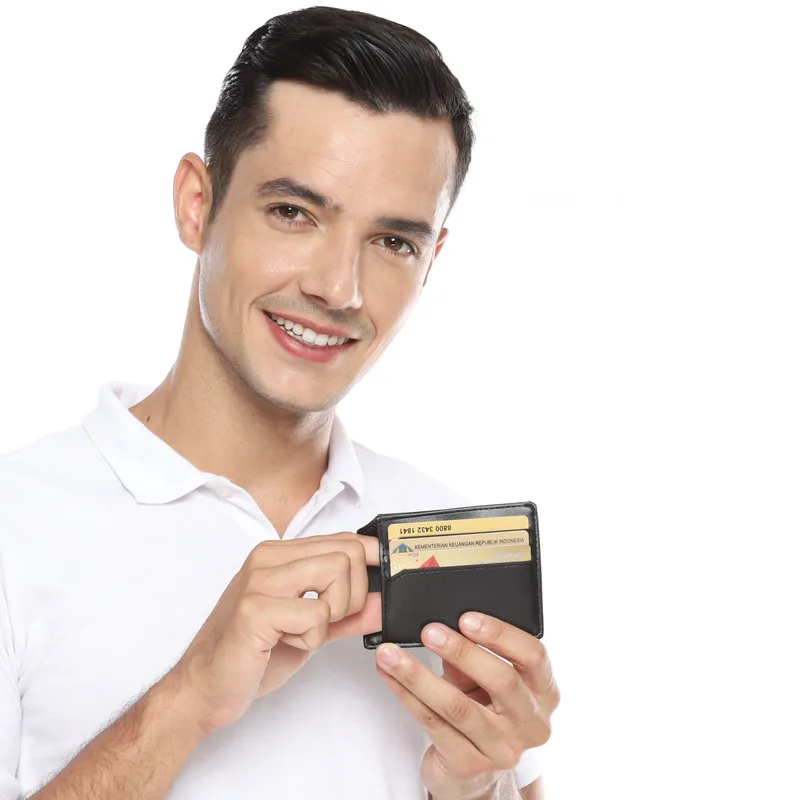 Pria tersenyum berkaus polo putih menarik kartu dari dompet tipis hitam yang dipegang dengan dua tangan