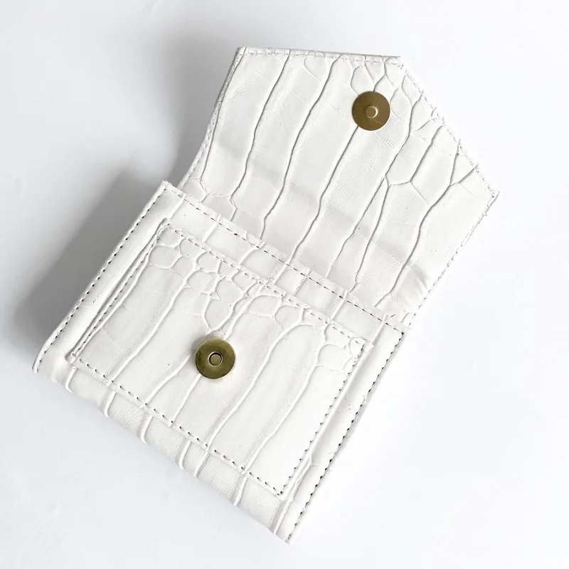 Dompet lipat putih bermotif croco dengan kancing magnet keemasan, tertutup dan diletakkan miring di atas latar putih
