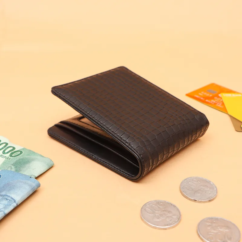 Dompet lipat hitam bertekstur kotak-kotak seperti anyaman di atas latar oranye muda, dengan uang kertas, kartu, dan koin di sekitarnya