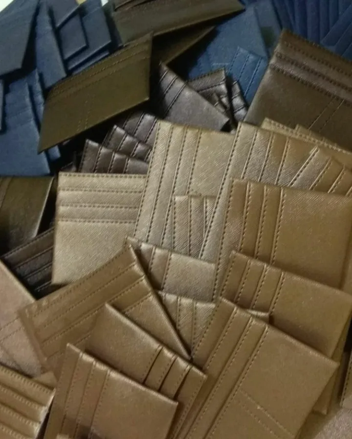Tumpukan card holder dengan beberapa slot kartu berjahit dalam warna emas tua, cokelat, dan biru dongker