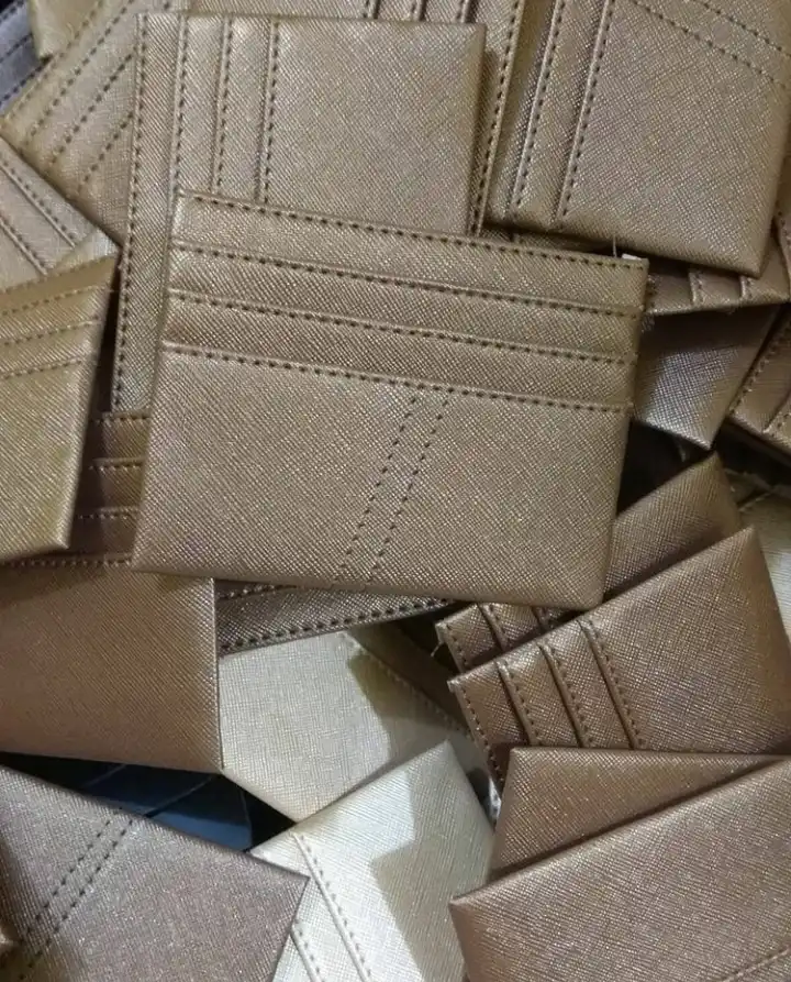 Close up card holder warna emas tua dengan garis jahitan lurus di sekeliling tepi dan di setiap batas slot kartu