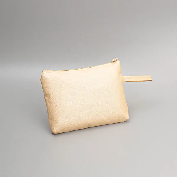 Pouch kapal berwarna krem muda dengan permukaan sedikit berkilau dan tali tangan, difoto dari samping di atas latar abu-abu