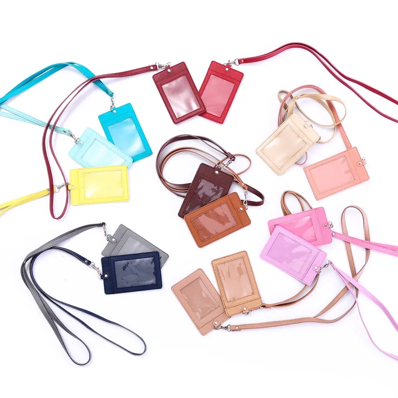 Belasan ID card holder dengan jendela plastik bening dan tali panjang dalam berbagai warna, antara lain biru muda, kuning, merah, cokelat, krem, merah muda, abu-abu, dan biru tua, tersebar di atas latar putih