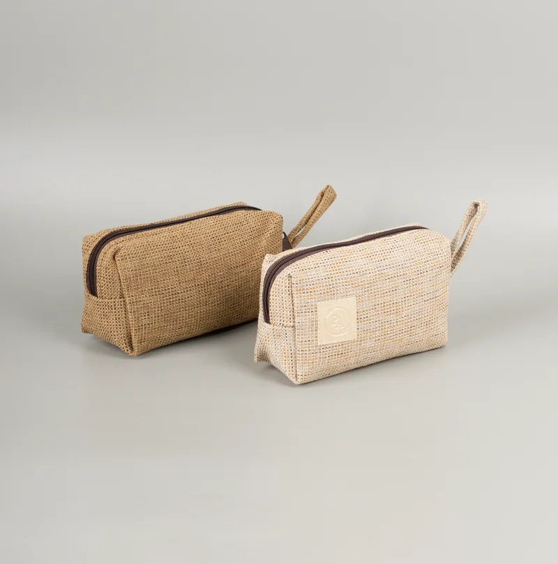 Dua pouch kubus bertekstur anyaman warna cokelat muda dan krem dengan ritsleting dan tali pegangan