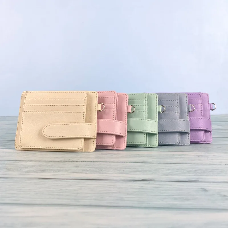 Lima card holder berjajar di atas meja kayu putih, masing-masing warna krem, merah muda, hijau mint, abu-abu, dan ungu, dengan tali pengunci dan ring logam kecil