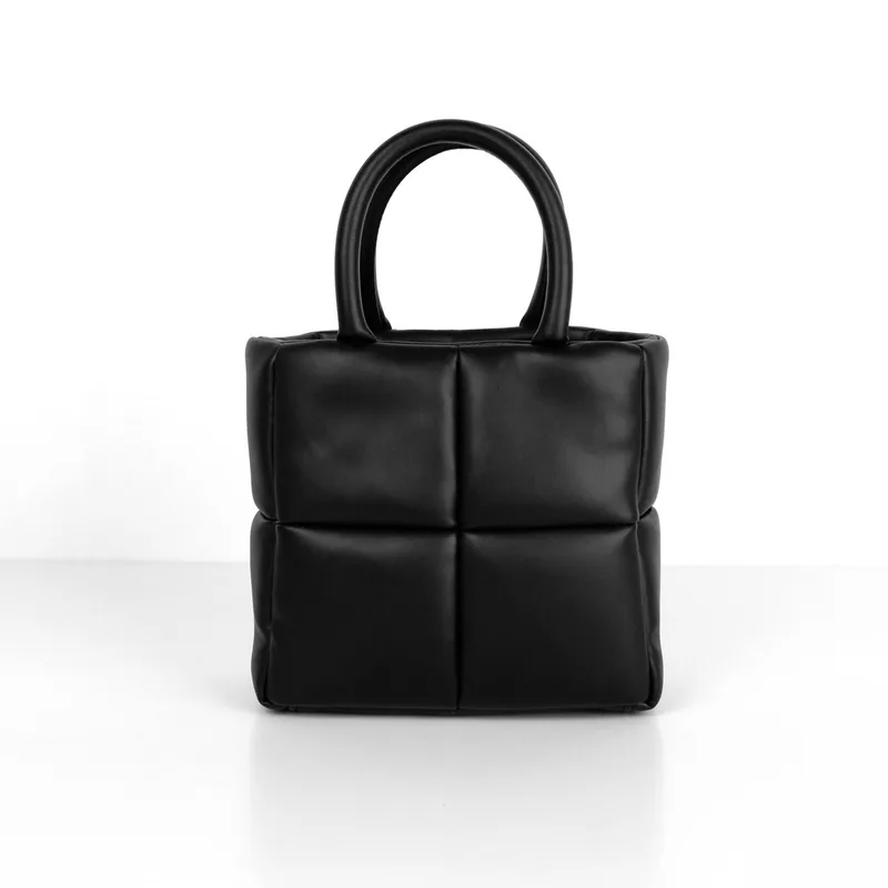 Tas tangan kecil warna hitam berpanel kotak empuk dengan dua pegangan bulat pendek di atas latar putih