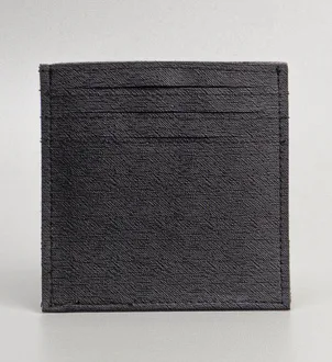 Card holder persegi berwarna hitam dengan tekstur halus bergaris dan tiga slot kartu yang terlihat di bagian atas, berdiri di atas permukaan abu-abu