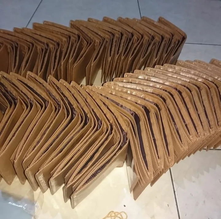 Ratusan dompet lipat cokelat muda berdiri berjajar di lantai keramik
