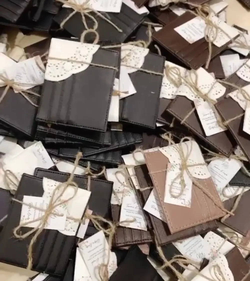 Tumpukan card holder cokelat yang dibungkus kertas renda, diikat tali rami, dan diberi kartu ucapan