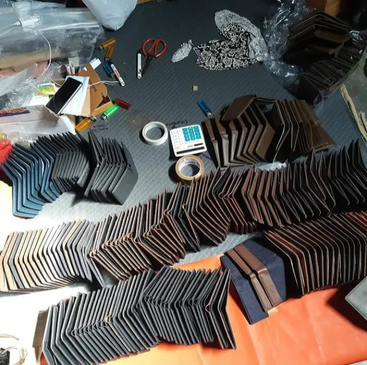 Meja kerja dengan gunting, lakban, kalkulator, dan deretan card holder warna gelap yang berdiri berjajar