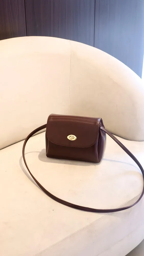 Belly Slingbag cokelat tua di atas sofa